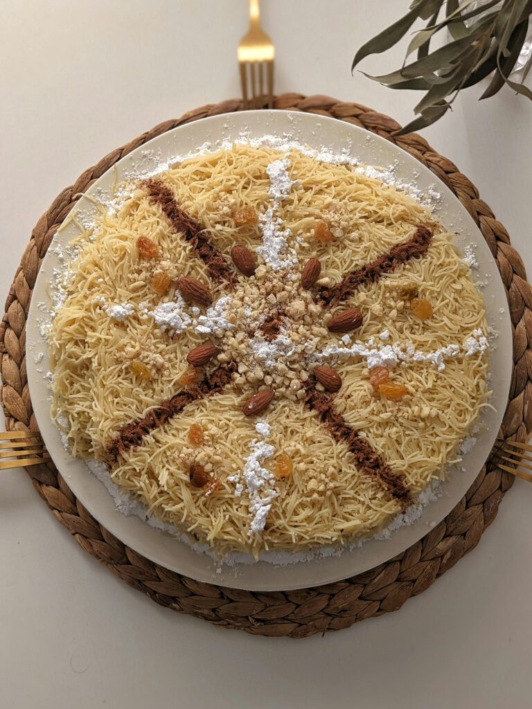 Delicious Moroccan Seffa Medfouna with almonds, raisins, and powdered sugar.